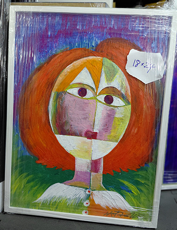 Painting of a stylized face with orange hair and green eyes.